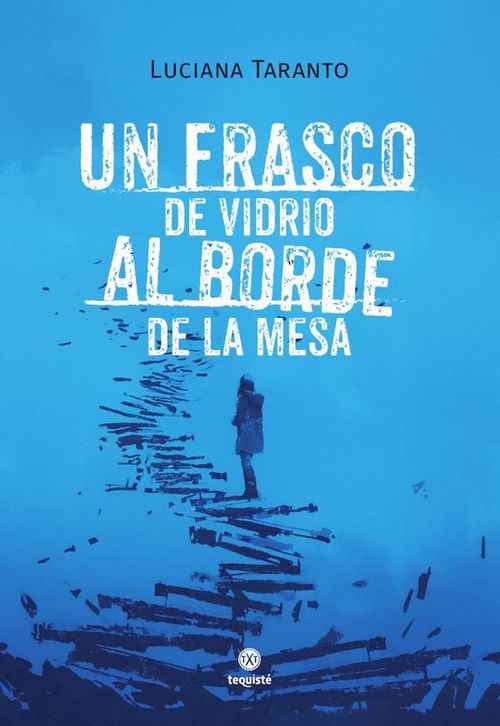 Un frasco de vidrio al borde de la mesa